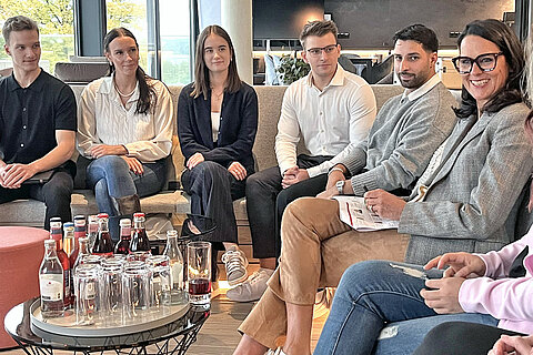 CEO Natalie Mekelburger und die neuen Azubis tauschen sich in angenehmer Lounge-Atmosphäre aus