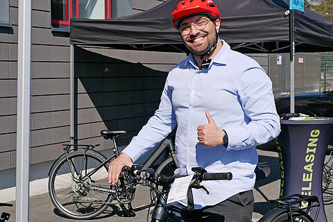 Employee in a red bike helmet, excited about the test ride offer.