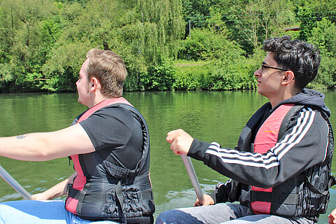 Zwei Azubis beim Rudern des Rafting-Boots