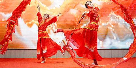Stage show at the WeWire Gala with traditional dance in the colors red and orange, representing the Year of the Snake.