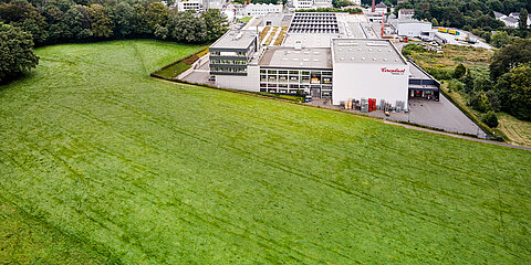 Ansicht von Produktions- und Verwaltungsgebäuden am Standort Wuppertal, eingebettet ins Bergische Land