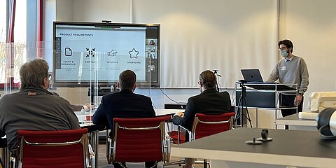 A student explains his design idea in a conference room of WeWire in Wuppertal