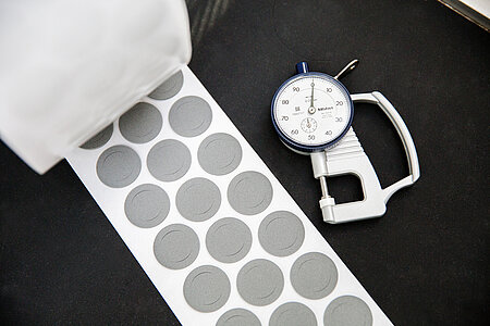 Roll of die-cut parts with measuring instrument