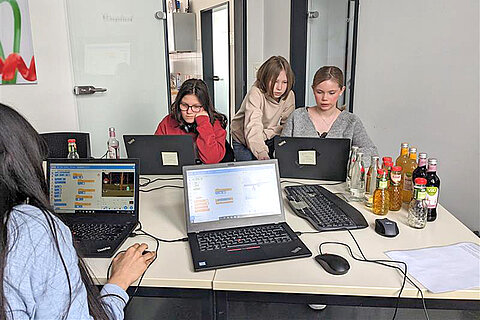 Vier Teilnehmerinnen an Laptops in der IT-Abteilung