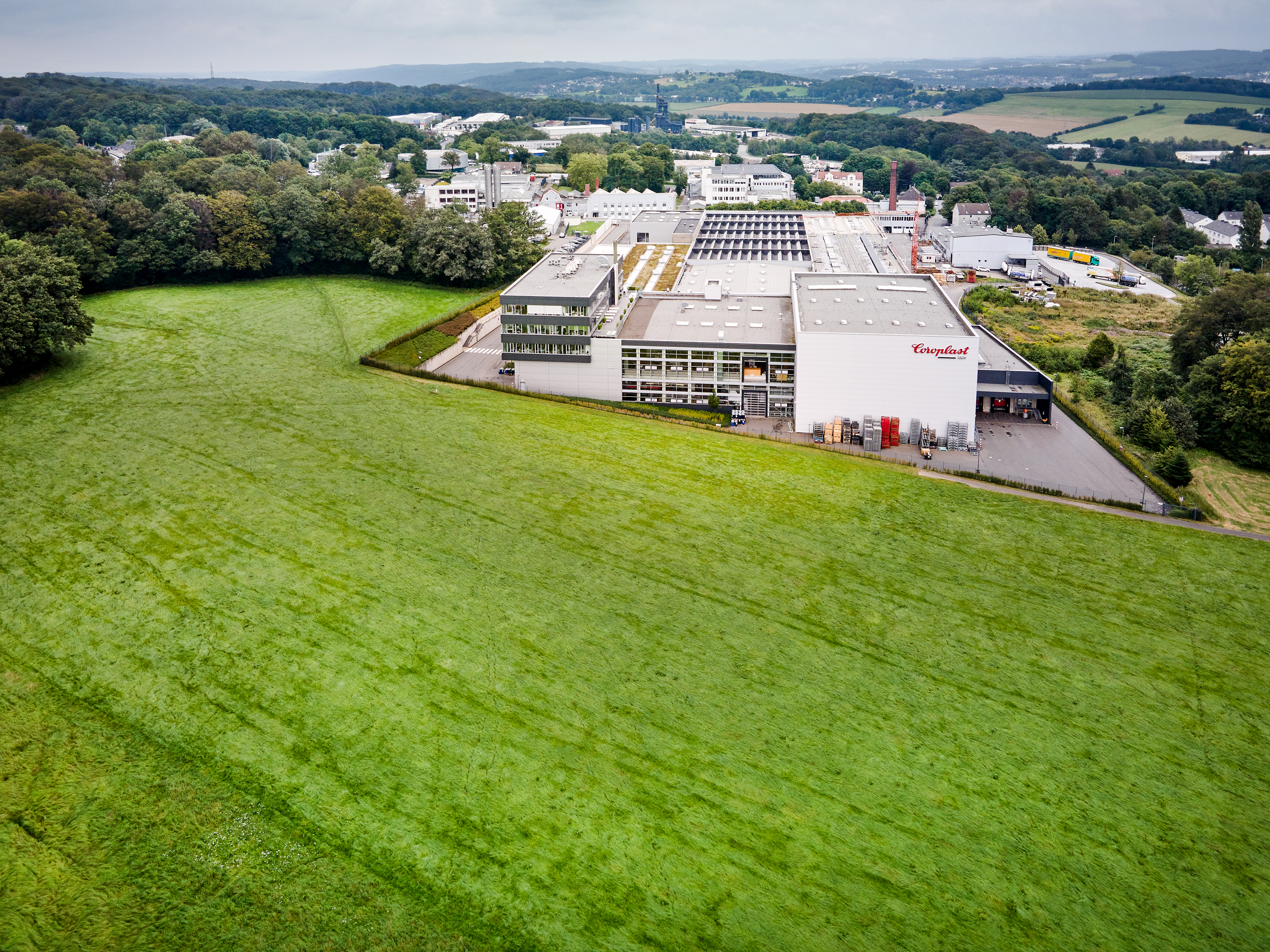 Ansicht von Produktions- und Verwaltungsgebäuden am Standort Wuppertal, eingebettet ins Bergische Land